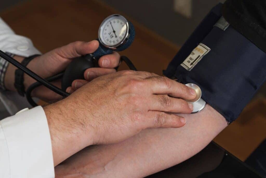 Medição da pressão arterial em paciente, destacando prevenção e controle da pressão alta.
