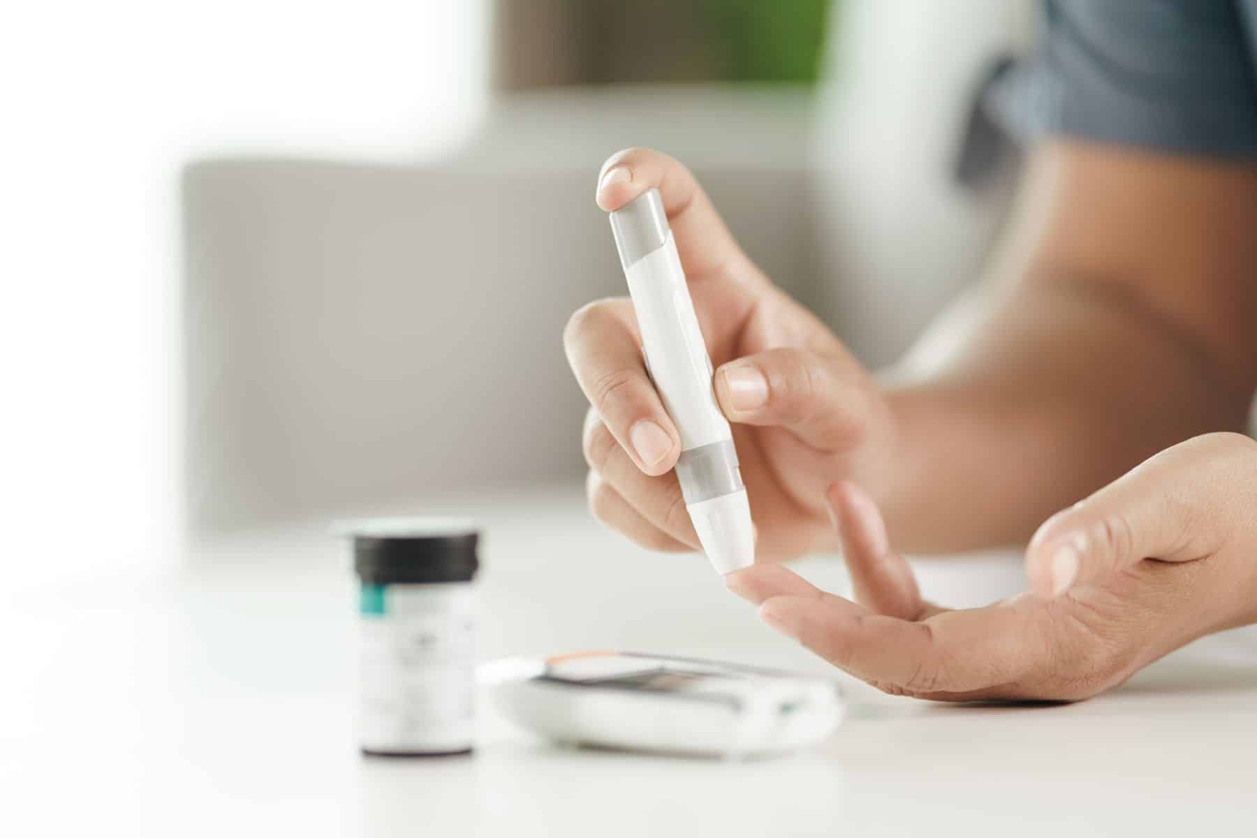 Mulher asiática com Diabetes tipo 2 medindo níveis de glicose no sangue com medidor.