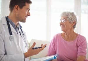 Médico explicando metas de colesterol para paciente idosa, representando acompanhamento cardiovascular especializado e orientações sobre prevenção.